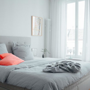 Mittelgroßes Modernes Hauptschlafzimmer ohne Kamin mit weißer Wandfarbe, braunem Holzboden und braunem Boden in Berlin