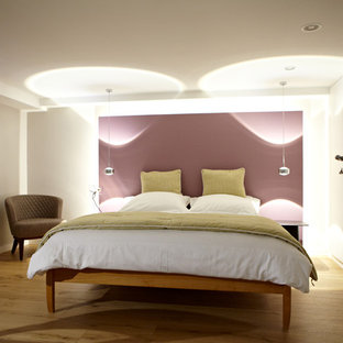 Modernes Schlafzimmer mit weißer Wandfarbe, hellem Holzboden und beigem Boden in Düsseldorf