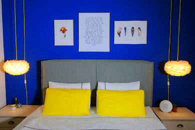 Mittelgroßes Modernes Hauptschlafzimmer mit blauer Wandfarbe und braunem Holzboden in Sonstige