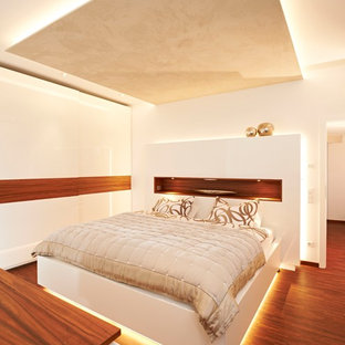 Mittelgroßes Modernes Hauptschlafzimmer ohne Kamin mit weißer Wandfarbe, braunem Holzboden und braunem Boden in Stuttgart