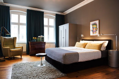 Mittelgroßes Eklektisches Hauptschlafzimmer mit grauer Wandfarbe, hellem Holzboden und braunem Boden