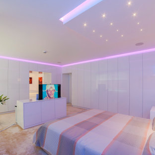 Imagen de dormitorio principal, minimalista, extra grande, con paredes blancas, moqueta y suelo beige