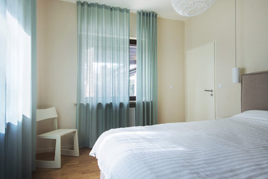 フランクフルトにある中くらいなモダンスタイルのおしゃれな主寝室 (グレーの壁、無垢フローリング、茶色い床) のインテリア