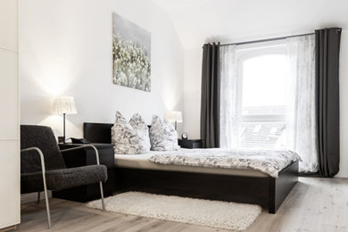 Großes Modernes Hauptschlafzimmer ohne Kamin mit weißer Wandfarbe und hellem Holzboden in Hannover