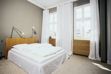 Ejemplo de dormitorio principal contemporáneo de tamaño medio sin chimenea con paredes grises y moqueta