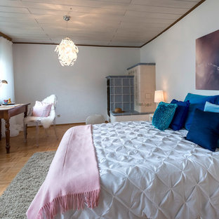 Großes Klassisches Hauptschlafzimmer mit weißer Wandfarbe, braunem Holzboden, braunem Boden, Kaminofen und gefliester Kaminumrandung in Frankfurt am Main