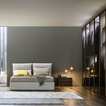 Schlafzimmer mit extravagantem Kleiderschrank mit transparenten Glastüren