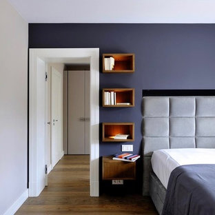 Großes Modernes Hauptschlafzimmer ohne Kamin mit lila Wandfarbe, dunklem Holzboden, Kaminumrandung aus Beton und braunem Boden in München