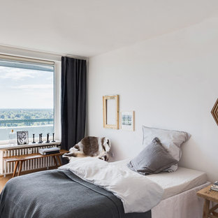 Mittelgroßes Nordisches Hauptschlafzimmer ohne Kamin mit weißer Wandfarbe, beigem Boden und hellem Holzboden in München