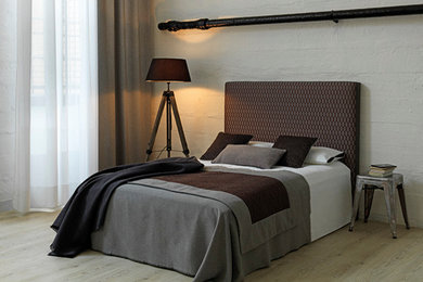 Industrial Schlafzimmer ohne Kamin mit weißer Wandfarbe und braunem Holzboden in Köln