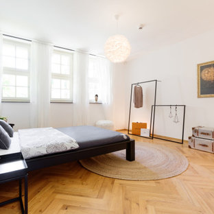 Modernes Schlafzimmer mit weißer Wandfarbe, braunem Holzboden und braunem Boden in Essen