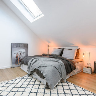 Kleines Nordisches Hauptschlafzimmer ohne Kamin mit weißer Wandfarbe, braunem Holzboden und braunem Boden in München