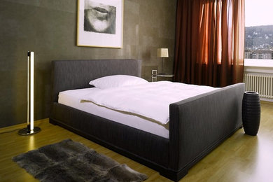 Modelo de dormitorio principal actual de tamaño medio con paredes multicolor y suelo de madera en tonos medios