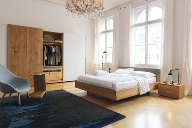 Пример оригинального дизайна: огромная хозяйская спальня в современном стиле с белыми стенами, паркетным полом среднего тона и бежевым полом без камина