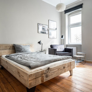 Mittelgroßes Modernes Hauptschlafzimmer ohne Kamin mit grauer Wandfarbe, braunem Holzboden und braunem Boden in Berlin