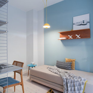 Imagen de habitación de invitados escandinava, pequeña, sin chimenea, con paredes azules y suelo de madera clara