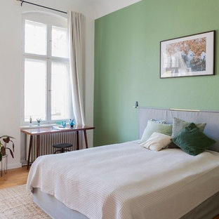 Mittelgroßes Modernes Hauptschlafzimmer ohne Kamin mit weißer Wandfarbe, braunem Holzboden und braunem Boden in Berlin