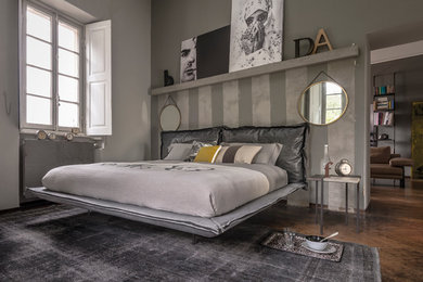 Großes Industrial Schlafzimmer ohne Kamin mit grauer Wandfarbe und braunem Holzboden in München