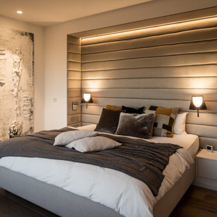 Modernes Schlafzimmer mit beiger Wandfarbe, dunklem Holzboden und braunem Boden in Bremen