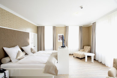 Großes Klassisches Hauptschlafzimmer ohne Kamin mit beiger Wandfarbe und hellem Holzboden in Frankfurt am Main