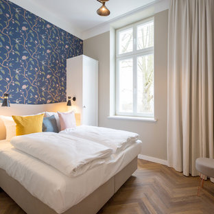 Mittelgroßes Modernes Hauptschlafzimmer ohne Kamin mit blauer Wandfarbe, braunem Holzboden und braunem Boden in Berlin
