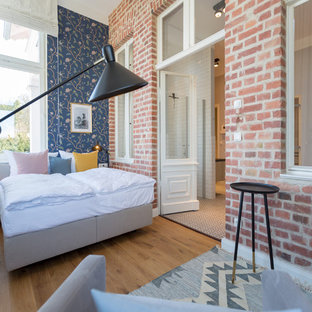 Mittelgroßes Modernes Hauptschlafzimmer ohne Kamin mit blauer Wandfarbe, braunem Holzboden und braunem Boden in Berlin