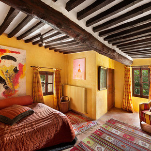 Diseño de dormitorio principal, mediterráneo, de tamaño medio, sin chimenea, con paredes amarillas y suelo de baldosas de terracota