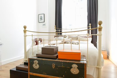 Ejemplo de dormitorio rústico pequeño sin chimenea con paredes blancas y suelo de madera clara