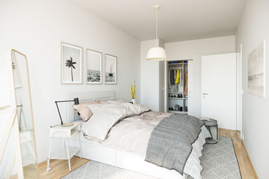Mittelgroßes Skandinavisches Hauptschlafzimmer mit weißer Wandfarbe, Laminat und braunem Boden in Hamburg