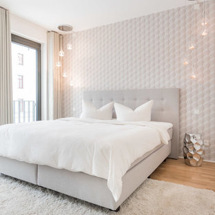 Mittelgroßes Skandinavisches Hauptschlafzimmer ohne Kamin mit weißer Wandfarbe, braunem Holzboden und braunem Boden in Berlin