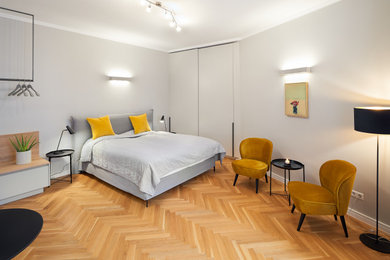 他の地域にある小さなコンテンポラリースタイルのおしゃれな主寝室 (グレーの壁、無垢フローリング、茶色い床) のレイアウト
