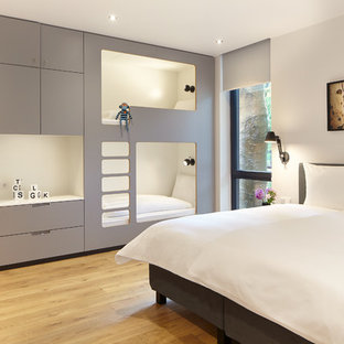 Mittelgroßes Modernes Gästezimmer ohne Kamin mit weißer Wandfarbe, hellem Holzboden und beigem Boden