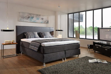 Geräumiges Shabby-Style Hauptschlafzimmer mit weißer Wandfarbe, Laminat und braunem Boden in Sonstige