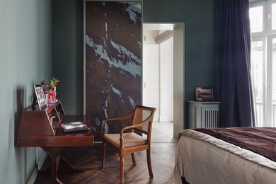 Mittelgroßes Stilmix Schlafzimmer ohne Kamin mit blauer Wandfarbe und braunem Holzboden in Berlin