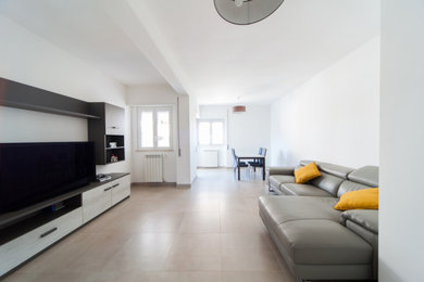 ローマにあるお手頃価格の中くらいな北欧スタイルのおしゃれなLDK (白い壁、磁器タイルの床、暖炉なし、壁掛け型テレビ、ベージュの床) の写真