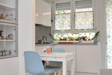 Idee per un piccolo soggiorno design aperto con pareti bianche, pavimento in gres porcellanato e pavimento grigio