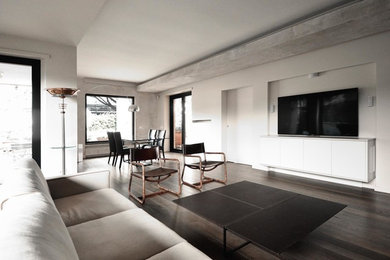 Modelo de salón abierto contemporáneo de tamaño medio con paredes blancas, suelo de madera oscura y suelo marrón