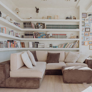 Immagine di un soggiorno contemporaneo con parquet chiaro, libreria, pareti bianche e pavimento beige