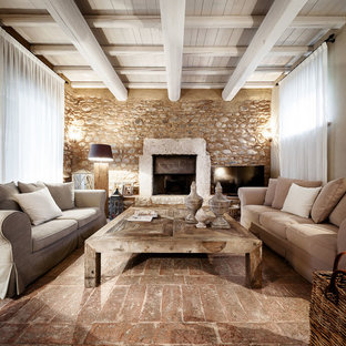 Immagine di un soggiorno country chiuso con pareti beige, camino classico, cornice del camino in pietra, TV autoportante e pavimento marrone