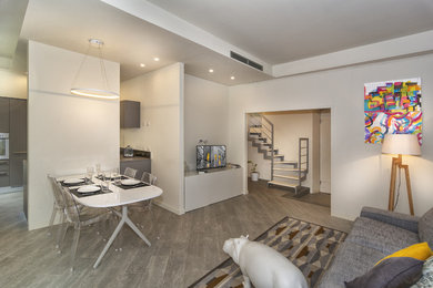 Ispirazione per un soggiorno minimalista stile loft con pareti bianche, pavimento in gres porcellanato, TV autoportante e pavimento grigio