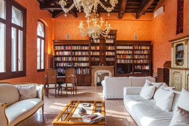 Idee per un ampio soggiorno tradizionale con pareti arancioni, camino classico, pavimento marrone e libreria