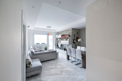 Esempio di un soggiorno design con pareti grigie, pavimento in marmo e TV a parete