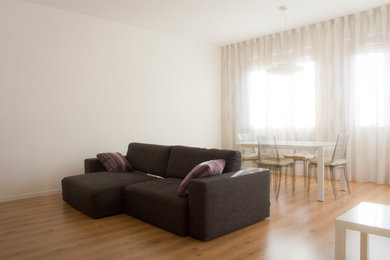 Immagine di un soggiorno minimal di medie dimensioni e aperto con pareti bianche, parquet chiaro, nessun camino, TV a parete e pavimento beige