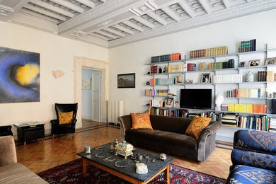 Foto di un soggiorno boho chic chiuso con libreria, pareti bianche e pavimento in terracotta