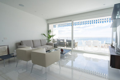 Cette photo montre un très grand salon moderne ouvert avec un mur blanc, un sol en marbre, un téléviseur encastré et un sol beige.