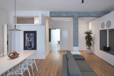 Idee per un soggiorno design di medie dimensioni e chiuso con pareti bianche, nessun camino, parete attrezzata, pavimento in legno massello medio e pavimento marrone