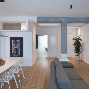 Idee per un soggiorno design di medie dimensioni e chiuso con pareti bianche, nessun camino, parete attrezzata, pavimento in legno massello medio e pavimento marrone