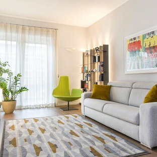 Immagine di un soggiorno design di medie dimensioni e chiuso con TV autoportante, nessun camino, pavimento marrone, pareti grigie e pavimento in legno massello medio