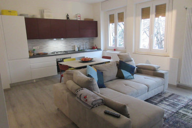 Esempio di un soggiorno minimal aperto con pareti bianche, pavimento in laminato e pavimento grigio