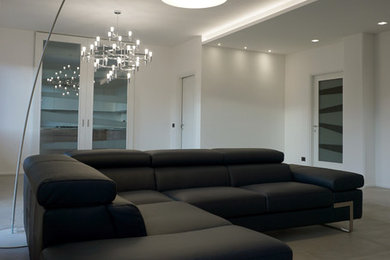 Foto de sala de estar abierta contemporánea grande con paredes blancas, suelo de baldosas de porcelana y suelo gris
